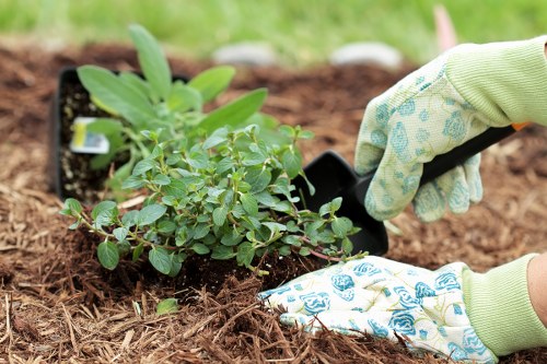Gardeners operating safely with PPE and controlled work area signage